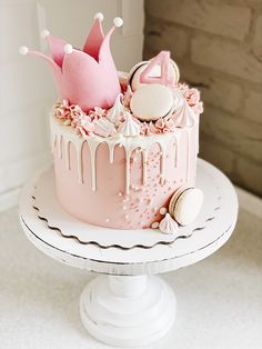 a pink cake with white icing and decorations