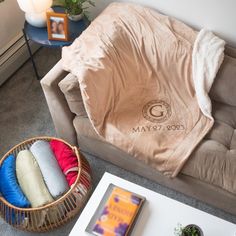 a living room filled with furniture and a blanket on top of a couch next to a coffee table