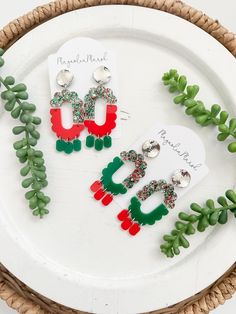 Show off your Christmas cheer with this new earring style! This listing is for one pair of acrylic split oval scalloped earrings. The top half of these split earrings are a mix of red, green and silver colored glitter followed by your choice of red with green dangles or green with red dangles. These are completed with silver circle studs. These are only available in limited quantities. Due to the handmade nature of this item, pattern placement may vary. Acrylic Split Oval Scalloped Earrings  Approximate size:  ~2.75" Are you new to cork and leather earrings? They are lightweight, the perfect accessory to ANY outfit and highly addicting! Looking for a different acrylic option? We are happy to create a custom pair for you!                    *THANK YOU SO MUCH* Thank you for shopping with Ma Earrings Silver Studs, Dangle Earrings Silver, Earrings Acrylic, Holiday Earrings, Glitter Earrings, Silver Circle, Circle Studs, Earrings Red, Green Earrings