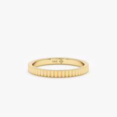 a yellow gold band ring on a white background