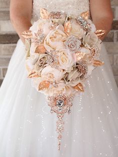 the bride's bouquet is made up of roses, brooches and pearls