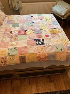 a bed with a colorful quilt on it in a small room next to a window