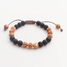 The rugged textures of natural lava stone are juxtaposed with sleek bone beads inscribed with chakra motifs. With this unity bracelet Ayu Ary responds to the world's differences with a beautiful piece of jewelry. Strung on a cotton cord the bracelet's macrame sliding knot clasp makes the length adjustable. Holistic Wooden Beaded Bracelets For Meditation, Hand-strung Lava Stone Bracelets, Spiritual Festival Bracelets With 108 Beads, Holistic Wooden Beads Bracelets For Meditation, Spiritual Festival Bracelet With 108 Beads, Traditional Adjustable Beaded Bracelets With Natural Stones, Traditional Adjustable Beaded Bracelets With Wooden Beads, Adjustable Traditional Beaded Bracelet With Wooden Beads, Spiritual Wooden Beaded Healing Bracelets