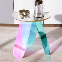 a glass table with an abstract design on it's legs and a vase next to it