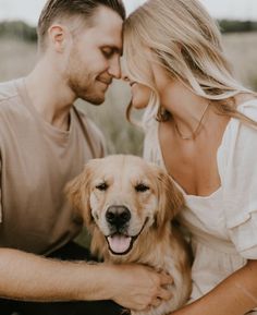 a man and woman sitting next to a dog