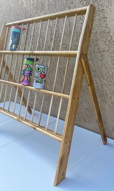 a wooden rack with magazines on it sitting next to a wall and cement flooring