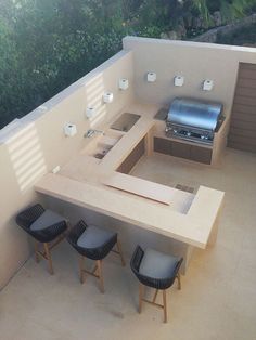 an outdoor kitchen with grill and seating area