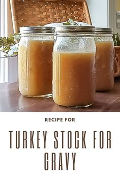 two jars filled with turkey stock sitting on top of a table next to a wicker basket