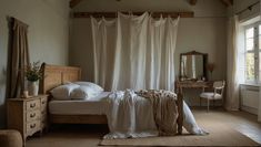 a bed sitting in a bedroom next to a window with curtains on top of it