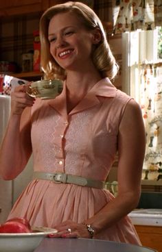 a woman in a pink dress holding a cup