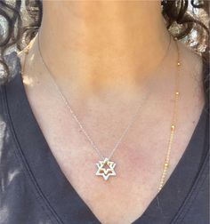 Sterling silver and 14k gold combine in this exquisite, timeless piece.   Discover elegance with our Star of David necklace featuring two delicately crafted pendants. The Star of David pendants shine with the brilliance of sterling silver and 14k gold, symbolizing faith, unity, and heritage. Perfect for everyday wear or as a meaningful gift, this necklace combines traditional craftsmanship with modern style. The adjustable chain (16 inches plus 2 inch extension) ensures a perfect fit, making it a versatile addition to any jewelry collection. Elegant Silver Jewelry With Star Charm, Elegant Silver Star Of David Necklace, Silver Star Of David Necklace For Formal Occasions, Elegant Silver Necklace With Star Charm, Elegant Silver Star Charm Necklaces, Elegant Star Of David Hallmarked Necklace, Formal Silver Star Of David Necklace, Sterling Silver Star Of David Necklace With Polished Finish, Silver Star Of David Fine Necklace