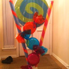 an assortment of colorful candy canes on display in front of a door with balloons