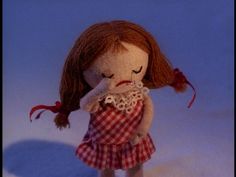 the doll is wearing a red and white checkered dress with her head in her hands