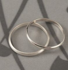 This is the perfect pair! A wedding set consisting of two solid sterling silver rounded traditional bands, they are hand crafted just for you. One is a 5mm wide rounded band and the other is a 2mm wide half round band. They can be finished with either a high polished or brushed finish. The rings depicted in this listing showcase the high polished option. The third photo shows the 2mm ring with both the polished and brushed finish for the sake of comparison. Please let us know your choice of fini Adjustable Sterling Silver Wedding Jewelry, Classic Wedding Stackable Rings With Simple Design, Minimalist Sterling Silver Wedding Bands, Minimalist Wedding Bands In Sterling Silver, Classic Wedding Bands With Simple Design, Silver Couple Rings For Anniversary With Simple Design, Silver Couple Rings With Simple Design For Anniversary, Wedding Stackable Rings With Adjustable Fit, Silver Wedding Rings With Simple Design