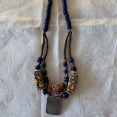 Handmade Necklace By Santa Fe Artist Terry Hawn. The Necklace Is 17" Long And Made Of Antique African Trade Beads With An Antique Silver Afghani Pendant. Blue Artisan Necklace With Large Beads, Artisan Blue Necklace With Large Beads, Blue Wooden Beads Round Jewelry, Artisan Blue Jewelry With Large Beads, Blue Wooden Round Beads Jewelry, Blue Wooden Beaded Round Jewelry, Blue Artisan Jewelry With Colorful Beads, Artisan Blue Jewelry With Colorful Beads, Gold Amulet Beaded Necklace With Colorful Beads