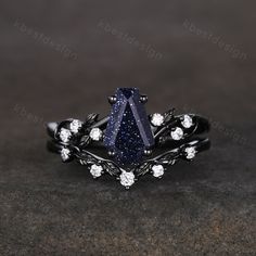 this is an image of a ring with blue and white stones on it, set in black gold