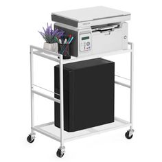 a white printer on wheels with a black box and purple flowers in the bottom right corner