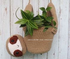 a crocheted planter with a stuffed animal hanging from it's side