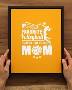 two hands holding up a framed print with the words my favorite volleyball player calls me mom