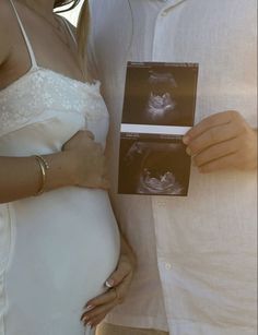 a pregnant couple holding an x - ray image in their hands and posing for the camera