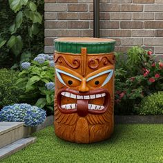 a large wooden tiki statue sitting on top of a lush green field next to a brick wall