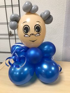 a bunch of balloons sitting on top of a table next to a balloon with a face