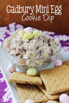 a bowl filled with cookies and marshmallows next to crackers on a plate