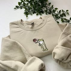 ✿ Flower Frog Embroidered Sweatshirt 🐸🌸 - ✿ Frog with flower embroidered on a unisex sweatshirt! an amazing gift idea!  - ✿ This design can be done on different coloured sweatshirts and with different coloured thread, as well as on totes, t-shirts and hoodies so please message me if you'd like to personalise it!  - ✿ Please look at the last slide for the size guide! I do not accept returns if you pick the wrong size, so please make sure you choose the correct one!  - ✿ I have lots of other ite Embroidered Clothes Ideas, Hoodie Embroidery Ideas, Embroidery Sweatshirt Ideas, Sweatshirts Ideas, Frog Sweater, Embroidered Frog, Frog Embroidery, Frog Sweatshirt, T Shirt Embroidery