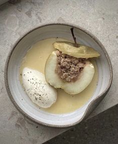 a white bowl filled with food on top of a cement counter next to a window