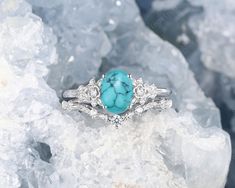 a turquoise stone ring sitting on top of some ice crystals