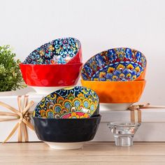 three colorful bowls sitting on top of a counter