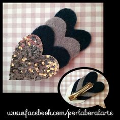 two black and silver heart shaped brooches on top of a checkered table cloth