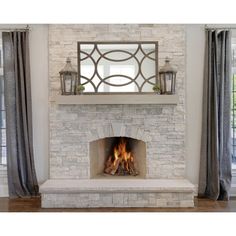 a fire place with a mirror above it