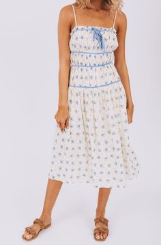 All dressed up and feeling fine, the Cry Baby Dress has got you covered. With adjustable straps and a fully lined design, this dress is as comfortable as it is stylish. The blue floral pattern and piping details add a touch of whimsy, while the front tie and pockets make it both practical and playful. Simply put, it's the perfect combination of fashion and function! Details Adjustable straps Fully lined Blue floral pattern Blue piping details Front tie detail Pockets Sizing Approximate measureme Blue Midi Dress With Spaghetti Straps For Garden Party, Blue Spaghetti Strap Midi Dress For Garden Party, Light Blue Floral Dress With Spaghetti Straps, Light Blue Floral Print Dress With Spaghetti Straps, Light Blue Spring Dress With Adjustable Straps, Lined Sundress With Spaghetti Straps For Garden Party, Cream Sundress With Spaghetti Straps For Spring, Blue Sleeveless Midi Dress With Ditsy Floral Print, Light Blue Lined Spaghetti Strap Dress