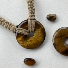 Donut gemstone design can be warn as necklace or choker! This shimmery tiger eye donut stone is quite large at 40mm wide and about 6mm thick (photos show front and back). The hemp chain is braided in a square knot style and is about 18 inches long (can be shortened to a choker length on request). Attaches in the back with a wooden bead through knotted loop. Handmade Brown Cord Jewelry, Handmade Cord Spiritual Jewelry, Handmade Cord Jewelry Gift, Brown Round Jewelry For Healing, Spiritual Cord Jewelry For Gifts, Adjustable Amber Crystal Necklaces, Adjustable Amber Crystal Necklace Round, Brown Adjustable Cord Jewelry For Healing, Adjustable Round Amber Crystal Necklace