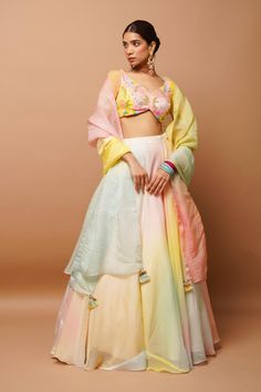 DETAILS: This set comes with a padded broad V-neck blouse with handwork. Full circular lehenga( cancan attached) Dupatta : Dupatta with details of Zari laces and handmade hangings. Handwork : beads, Resham , cutdana, sequence, zardosi and naksi Neckline: V-neck Sleeves:elbow sleeves Size and fit Bustier length: 13.5 inch Lehenga length: 44 inch Model Size: Model is wearing XXS Size Model Height: 5’7” Heels : 4 inches Fabric , colour and care Fabric: Heavy Organza Colour: Pastels (Pink,blue,yello Shagun Saree, Hand Painted Lehenga, Painted Lehenga, Haldi Outfits, Haldi Outfit, Pink Cape, Organza Lehenga, Lehenga Style, Indian Dresses Traditional