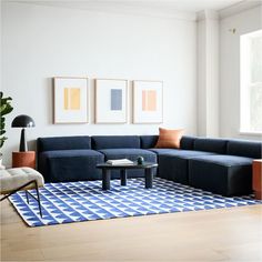 a living room with blue couches and pictures on the wall above it, along with a coffee table