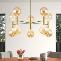 a modern chandelier hanging over a dining room table with flowers in vases