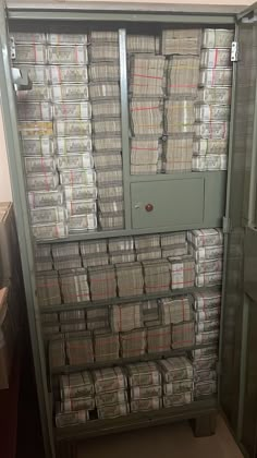 a large metal cabinet filled with lots of papers next to a wall full of files