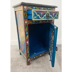 an ornately painted wooden cabinet on carpeted floor