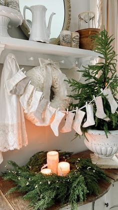 a christmas mantle with candles and stockings on it