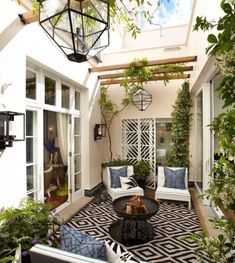 an outdoor living area with white furniture and plants