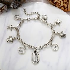 Escape to the seashore with this anklet depiccopperg silvery images of seashells, starfish and other marine life. 7.87" L with 1.96" extender Lobster claw clasp Silvertone copper Bar Station, Marine Life, Lobster Claw, Starfish, Anklets, Sea Shells, Silver Plate, Silver Bracelet, Silver Tone