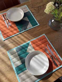 two placemats with plates and silverware on them