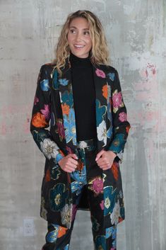 Elevate your wardrobe with this stunning long black blazer, featuring a bold multicolor mod floral and gold print that seamlessly blends classic elegance with contemporary flair. The tailored silhouette offers a flattering fit, perfect for layering over your favorite outfits, while the vibrant floral design adds a pop of color and personality. Crafted from premium fabric with attention to every detail, this blazer embodies both sophistication and fun, making it a standout piece for any occasion. Floral Print Outerwear For Party, Floral Print Party Outerwear, Multicolor Notch Lapel Blazer For Fall, Elegant Multicolor Floral Print Outerwear, Floral Print Long Sleeve Blazer For Party, Chic Floral Print Fall Blazer, Long Sleeve Floral Print Blazer For Party, Spring Party Outerwear With Floral Print, Chic Notch Lapel Outerwear With Floral Print