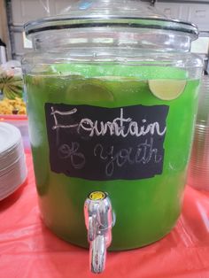 a jar filled with green liquid sitting on top of a table