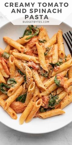 a white bowl filled with pasta and spinach