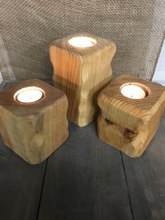 three wooden candles sitting on top of a table