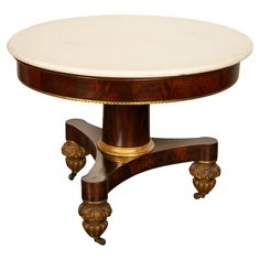 a round table with marble top and brass accents