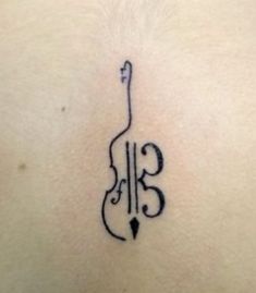 a tattoo on the back of a woman's stomach that has an image of a violin